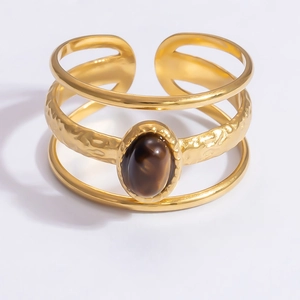 Detail of 18k gold open cuff bracelet featuring hammered texture and a brown gemstone