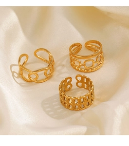 Detailed view of three adjustable gold-plated chain rings on elegant cream silk fabric
