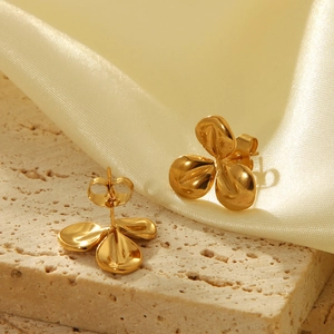 Vue macro détaillée des boucles d'oreilles fleur en or 18 carats sur base en pierre