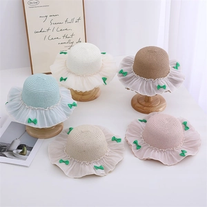 Handwoven straw sun hats for girls with ruffled lace trim and decorative green bows