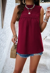 Detail view of burgundy sleeveless top with lace trim, pleated collar, and polka dot texture