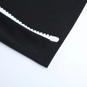 Détail d'une robe noire avec dentelle blanche et texture de tissu tissé de qualité