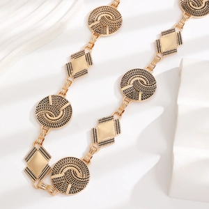 Detailed close-up of golden vintage bohemian waist chain with embossed metal links