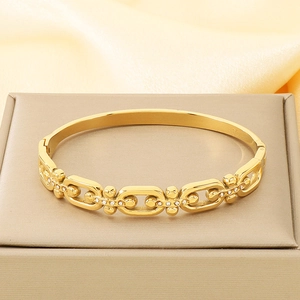 Detailed macro view of gold chain bracelet with rhinestones on a velvet jewelry box