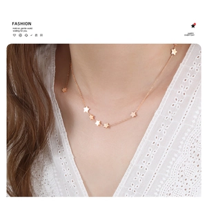 Close-up of rose gold star pendant necklace on a model with white lace clothing