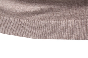 Detailed macro shot of the ribbed hem and brown knitted texture of the men's sweater
