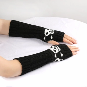 Close-up of black knitted arm warmers featuring white skull patterns for gothic style