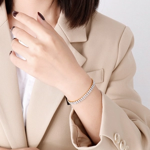 Bracelet élégant en acier inoxydable doré avec zircones carrées porté par une femme