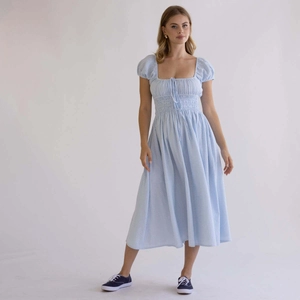 Primer plano detallado del corpiño fruncido azul claro y escote cuadrado en el vestido midi