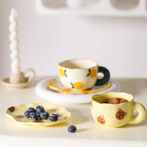 Cute ceramic coffee cup and saucer set featuring hand-painted bears and lemons