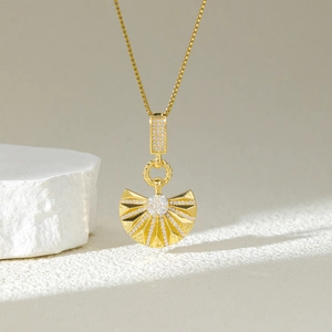 Golden fan-shaped pendant necklace with sparkling cubic zirconia and radiant textures
