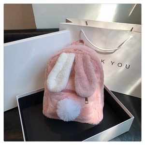 Detailed view of pink fuzzy rabbit backpack with long ears in a minimalist gift box
