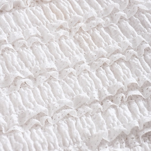 Vue macro détaillée du tissu en dentelle blanche à plusieurs niveaux plissés