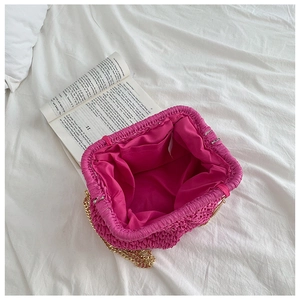 Interior view of rose red straw bag with inner pocket and golden metal chain strap