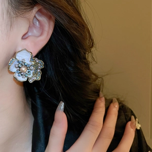 Close-up of vintage flower earrings with pearls and colorful crystals on a model