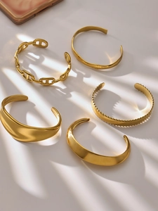 Juego de cinco brazaletes de acero inoxidable bañados en oro de 18k con texturas geométricas