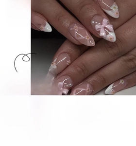 Detail of pink bow and 3D flower decorations on long almond French press-on nails