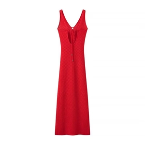 Détail d'une robe en maille rouge foncé avec col en V, dos nu lacé et texture au crochet fine