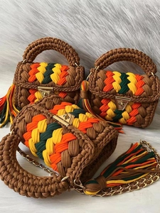 Handmade crochet handbag with colorful stripes, gold clasp lock and tassel details