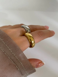 Nahaufnahme von goldenen und silbernen breiten Ringen mit polierter Spiegeloberfläche
