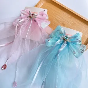 Close-up of pastel bow hair clips with pearls and snowflake charms on a wooden tray