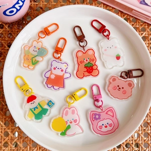 Set of 8 cute acrylic bear and bunny keychains displayed on a white round ceramic plate