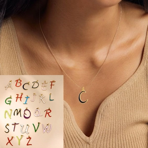 Detail of 26 colorful enamel alphabet pendants in gold finish worn by a model