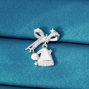 Christmas bow and Santa hat silver stud earring on blue silk background with clear zircons