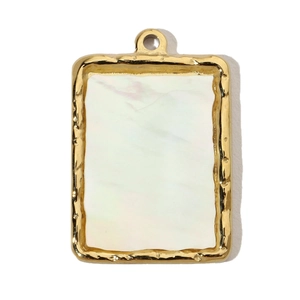 Detail of a rectangular golden titanium steel pendant with hammered texture and white shell