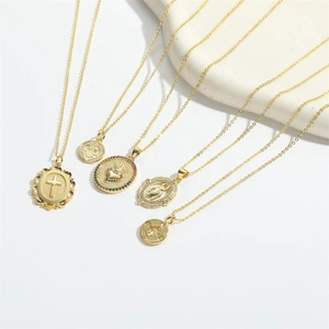 Close-up of five vintage gold pendant necklaces with cross, heart, and religious motifs