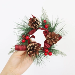 Christmas Norfolk pine wreath with red and black buffalo plaid bow and pine cones