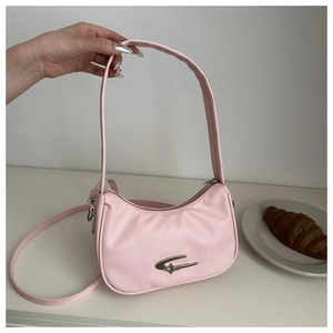 Close-up of pink crescent moon bag with silver logo detail and leather texture