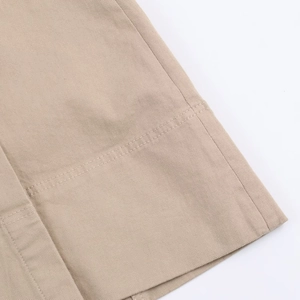 Dettaglio delle cuciture e del tessuto in cotone twill kaki sull'orlo della gonna midi