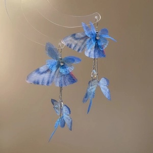 Detail of blue gradient butterfly earrings with long fringe tassels and waterdrop beads