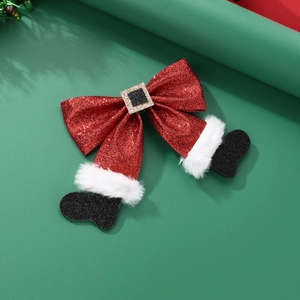 Detail of red sequin Christmas bow hair clip featuring Santa Claus boots design
