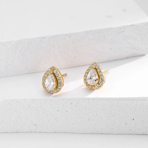 Detail of pear-shaped halo stud earrings with clear zircon stones on a gold base