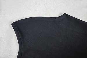 Detail view of the mock neck and seamless shoulder stitching on a black A-line maxi dress
