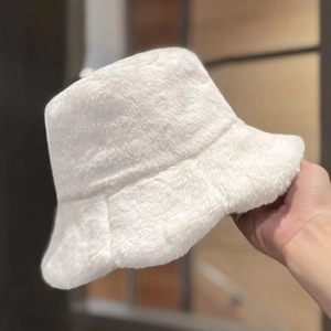 Plush white faux rabbit fur bucket hat for women winter warm accessory held by hand