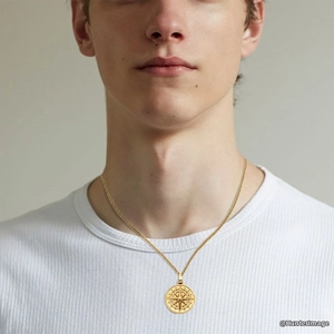 Detail of a men's gold compass pendant necklace with north star engraving on a fine chain