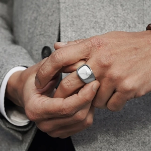 Vintage men's silver stainless steel ring with white marble stone inlay on a grey suit