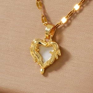 Macro shot of gold heart pendant with lava texture edge and white resin inlay detail