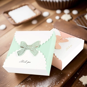 Macro detail of pink and green paper gift boxes with bow tie lids and Thank You print