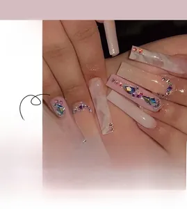 Détail de faux ongles marbre rose avec strass de luxe et forme carrée extra longue