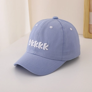 Detail of blue cotton baseball cap featuring white OKKKK embroidery and breathable eyelets