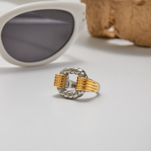 Gros plan d'une bague bicolore en acier inoxydable sur une surface en marbre texturé