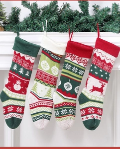 Close-up of four knitted Christmas stockings with reindeer and snowflake patterns