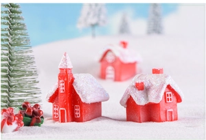 Macro shot of resin Christmas candy house miniatures with sparkling white snow rooftops