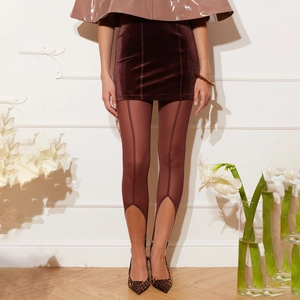 Détail d'une jupe en velours marron avec legging transparent et talons léopard