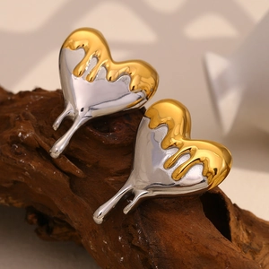 Detail of two-tone fluid lava effect heart studs on natural textured wood background
