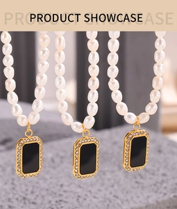 Detail of beaded pearl necklaces with gold-edged black rectangular pendants on stone